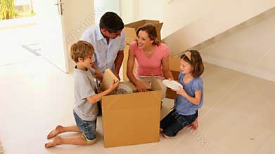 Happy family opening box in their new home