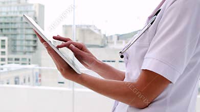 Nurse in tunic using tablet pc