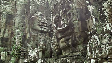 Huge stone faces on the walls of an ancient temple. Cambodia, Bayon