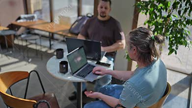Team of programmers coding on laptops working at creative office
