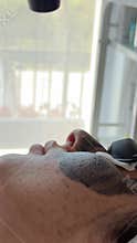 Young woman getting carbon laser facial at beauty clinic. Professional skincare
