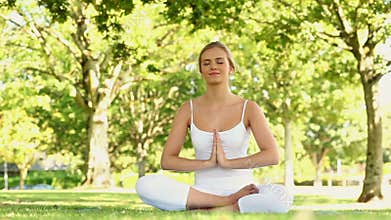 Calm blonde doing yoga in the park