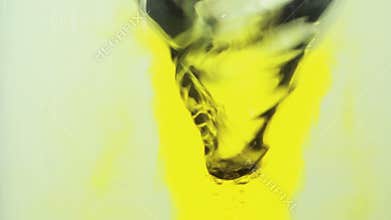 Yellow ink swirling into water whirlpool