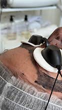 Young woman getting carbon laser facial at beauty clinic. Professional skincare