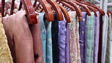 Colorful fabrics displayed on hangers in a clothing store