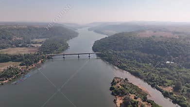 Aerial view of a bridge crossing the Karli River in a lush green valley in Maharashtra, India