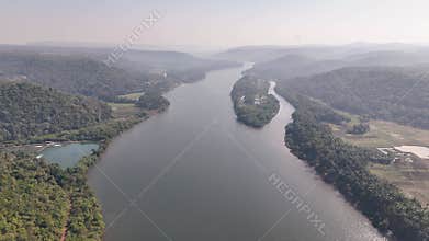 Expansive aerial view of the wide Karli River flowing through a lush green valley with a large island in Maharashtra, India