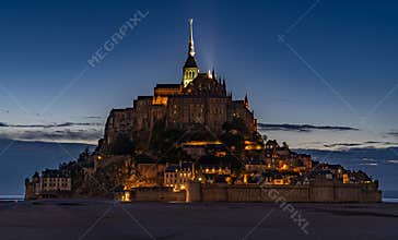 Famous Mont-Saint-Michel at dawn, illuminated by lights