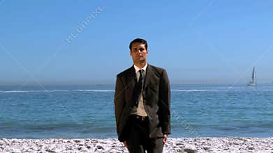 Funny businessman jumping and crossing the beach