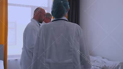 Medical team examining patient in hospital room