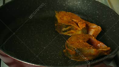 Marinated fish steaks frying in hot pan