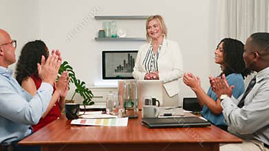 Empowered Business Leader Presents to Diverse Colleagues, Receiving Enthusiastic Applause in the Boardroom