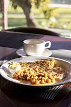 Omelette with chickpea stew, fried chicken crumb and boiled egg served with coffee