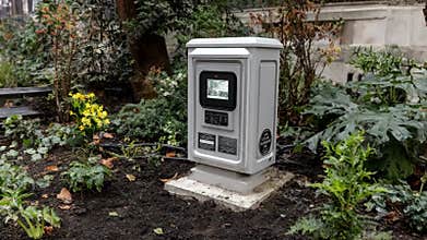 Medium shot of an ecofriendly copper monitoring unit installed in a green park highlighting sustainable design and clean