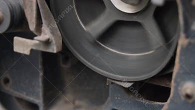 Close Up Of A Moving Compressor Belt On A Pulley System In A Dusty Industrial Environment