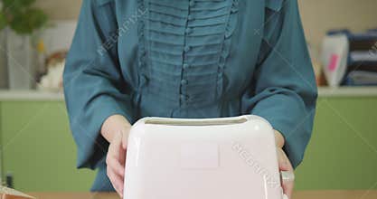 Person with blindness disability making toast in toaster