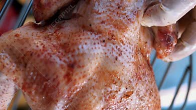 Raw marinated chicken legs arranged on metal rack for tandoor baking. Uncooked
