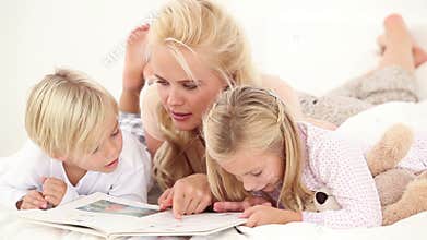 Mother reading book to her children