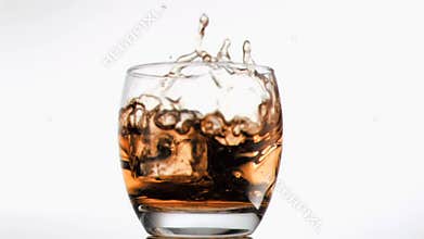 Ice cube falling in super slow motion in scotch