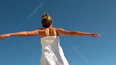 Carefree blonde spinning around on sunny day