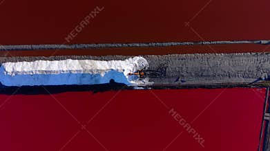 Top-Down Abstract View of Excavator Working on Salt Dike with Red Water