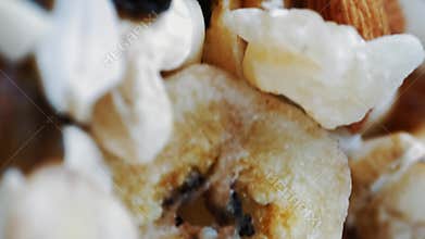 Nutritious assortment of cashews, almonds, and dried berries rotating together.