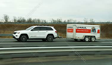 New Jersey, U.S - Jan 17, 2026 - A U-Haul trailer towed by Jeep Grand Cherokee SUV, promoting self-moving services and rental