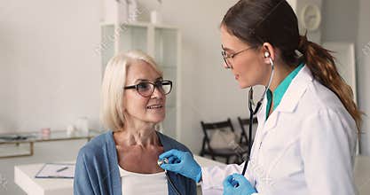 Cardiologist holding stethoscope, listening of middle age patient heartbeat
