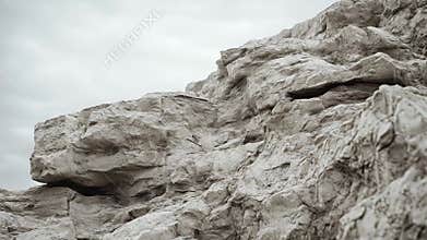 Rough limestone cliff face under overcast sky