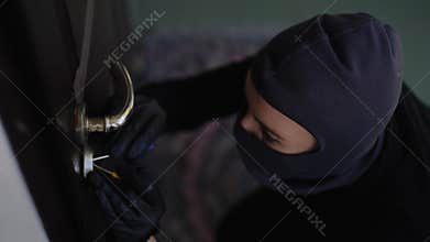 An Intruder is Attempting to Unlawfully Unlock a Door, Raising Security Concerns