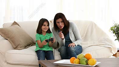 Cheerful mom encouraging her daughter to play video games