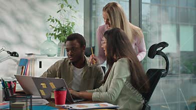 Three business team multiethnic colleagues in informal creative startup talk collaborate analyzing data in digital