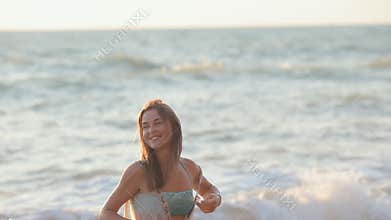 Happy girl runs along the beach and enjoys