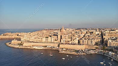 Drone view of Valletta waterfront, domes, and fortifications along the Mediterranean