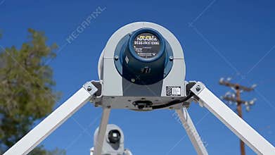 Close Up Production of Satellite Antenna Calibration on White Tripod Against a Clear Blue Sky Featuring Precision Engineering and