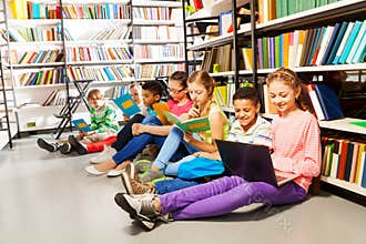 Children sitting on floor in library and studying