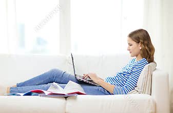 Busy teenage girl with laptop computer at home