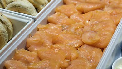 Fresh-looking pink salmon fillets neatly arranged in plastic tray.