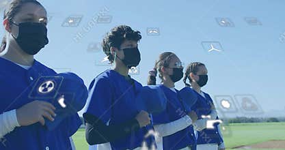 Standing six baseball players wearing blue jerseys and masks, holding caps on field with icons