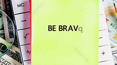 Explore financial strategies with a calculator, currency, and the empowering message BE BRAVE on a sticky note. Plan your success