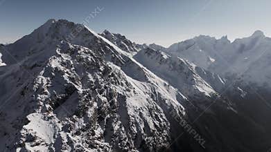 Aerial View. A breathtaking bird's-eye view of the majestic mountain ranges, showcasing the snow-capped peaks of the