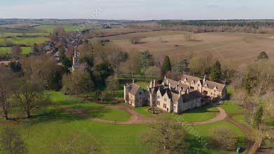 Aerial view of old manor house, stately home with Victorian era architecture and large green landscape