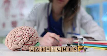 Word Catatonia on wood cubes and human brain model in hospital