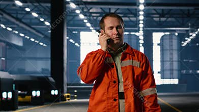 Technician using walkie talkie during job assignment in manufacturing facility