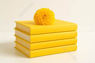 A Vibrant Arrangement Featuring Four Stacked Yellow Books Topped with a Bright Marigold