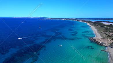 Formentera island coastline, boats on turquoise water. Magic aerial view drone