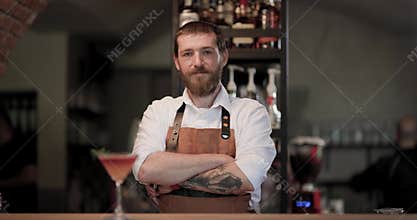 Barman prepares cocktails behind the bar in a busy