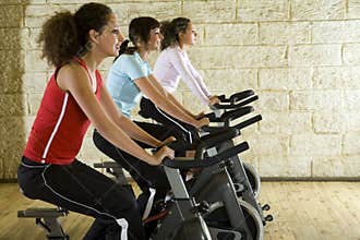 Young women on exercise bikes