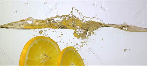 Slow motion oranges splash into water. Refreshing and vibrant macro footage