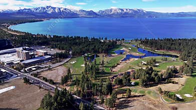 Aerial view of South Lake Tahoe golf course and town with lake and mountain background